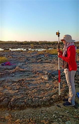Gina collecting elevation and distance measurements on rings of a fossilised coral microatoll with a surveying rod at the La Union field site (Source: Loraine Faye Sarmiento/University of the Philippines)