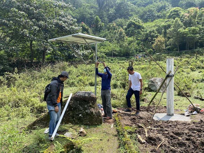 Dr Iwan Hermawan (in white), the CGO scientist leading the GPS installations, inspecting the quality of the GPS monument (Source: Juniator Tulius/Earth Observatory of Singapore)