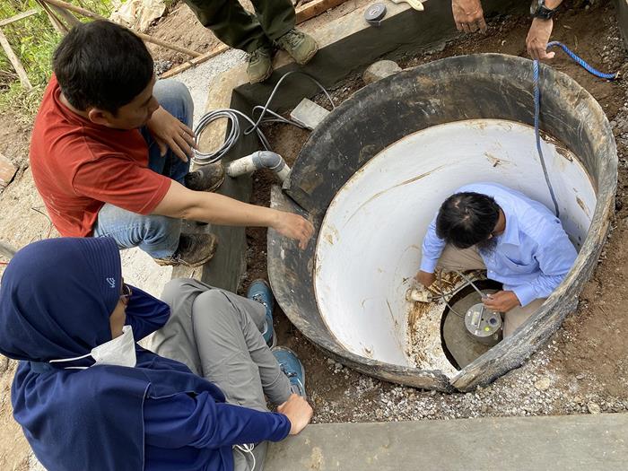 Dr Dannie Hidayat (in red), the CGO scientist leading the seismic installations, supervising the setup of the seismic sensor in the vault (Source: Juniator Tulius/Earth Observatory of Singapore)