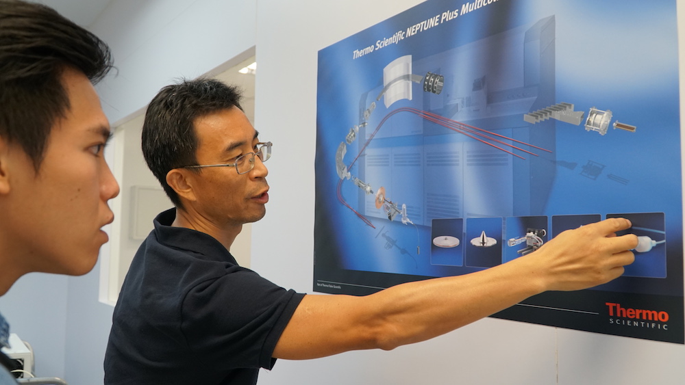 Assistant Professor Wang Xianfeng demonstrates how the mass spectrometer in his lab works (Source: Shireen Federico)