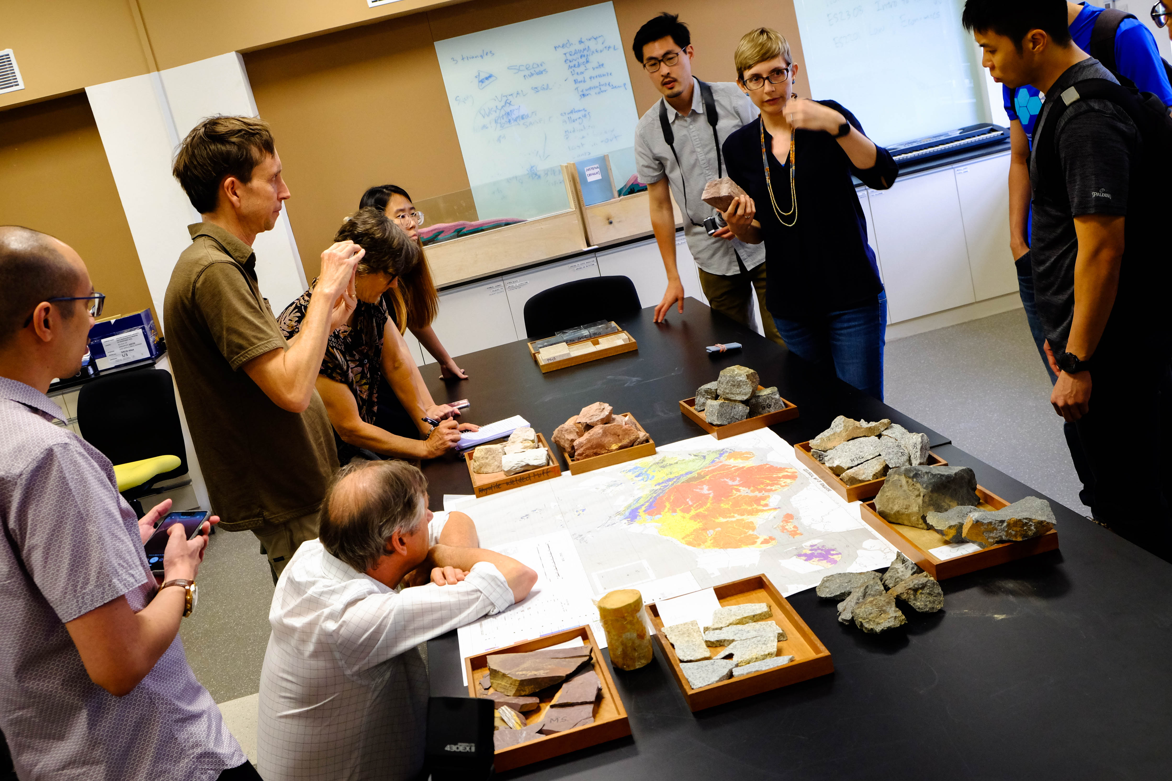 Dr Aurélie Coudurier Curveur, an EOS research fellow, showing the teams from Exploratorium and Science Centre the rocks collected from all over Singapore (Source: Kuang Jianhong/Earth Observatory of Singapore)