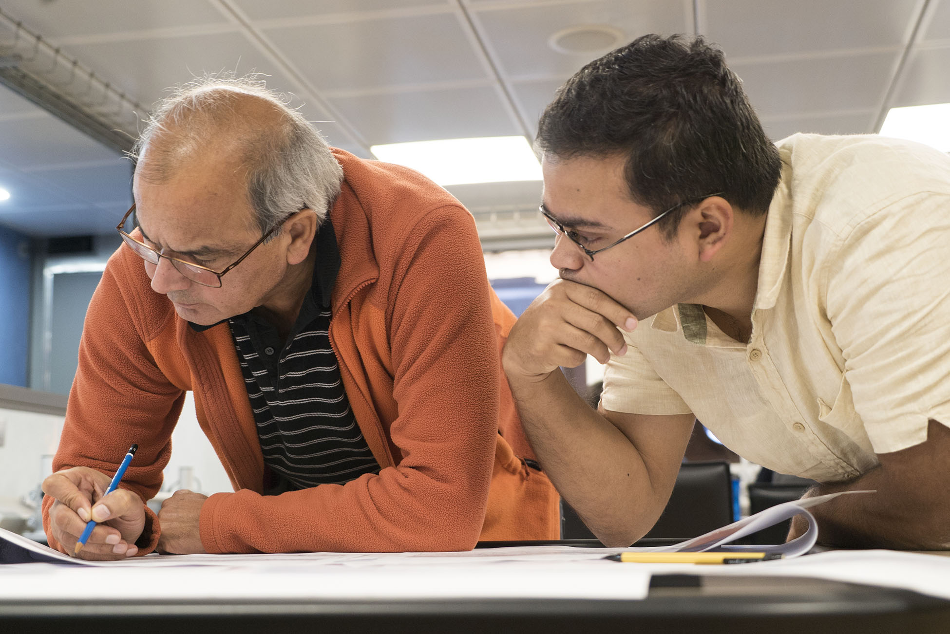 Chief Scientist Dr Satish Singh and geophysicist Dr Sudipta Sarkar, analyse some of the most recent seismic reflection profiles acquired during Mirage II (Source: EOS/ Monika Naranjo Gonzalez)